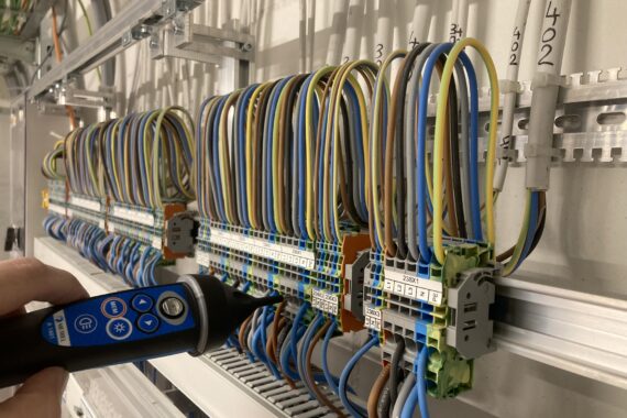 "Abgangsverdrahtung mit Messung" bedeutet, dass elektrische Leitungen mit einer Messung ihrer Funktion oder Leistung verbunden sind, Elektrokontrollen
